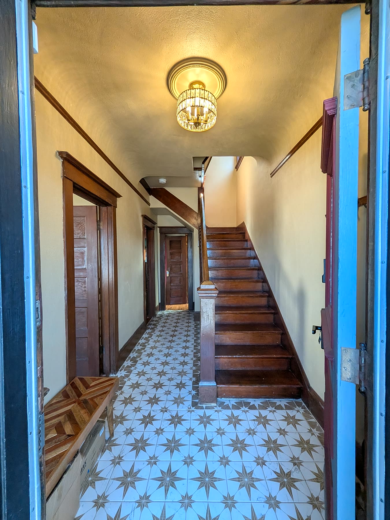 Entryway foyer with original staircase and star-pattern tile floor