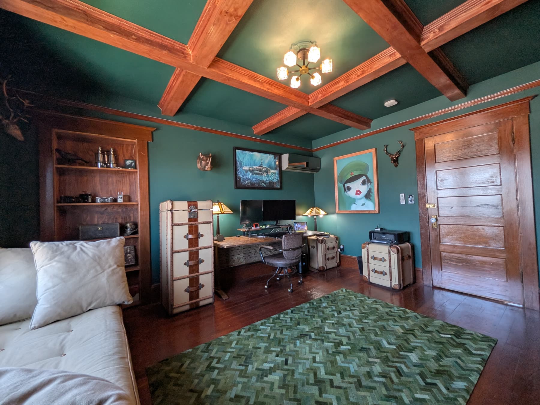 Green den with built-in shelving and beamed ceiling