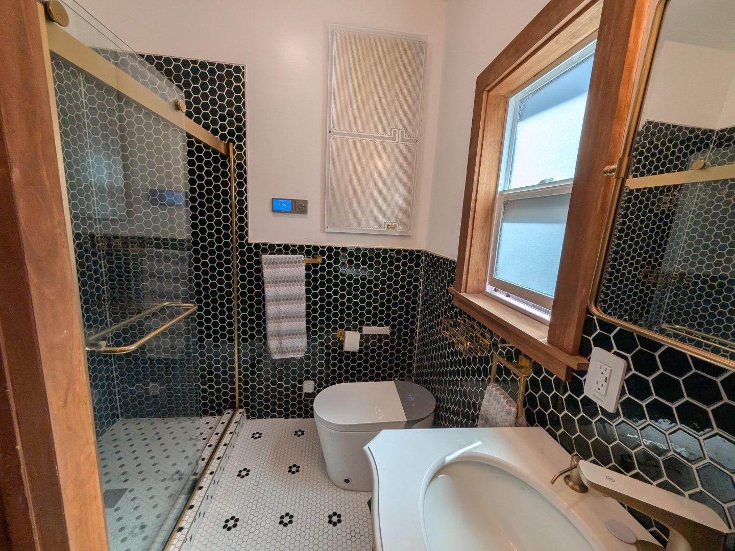Bathroom with black hexagonal tile and brass fixtures