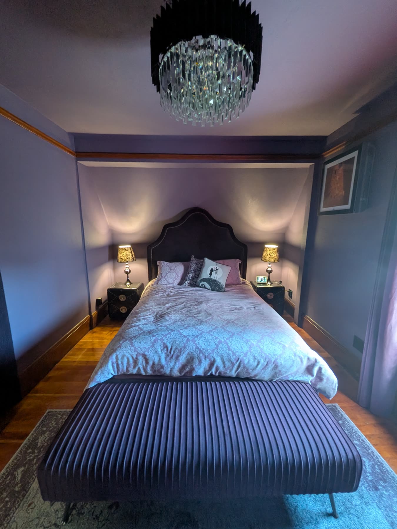 Primary suite with upholstered bed, chandelier and period detailing
